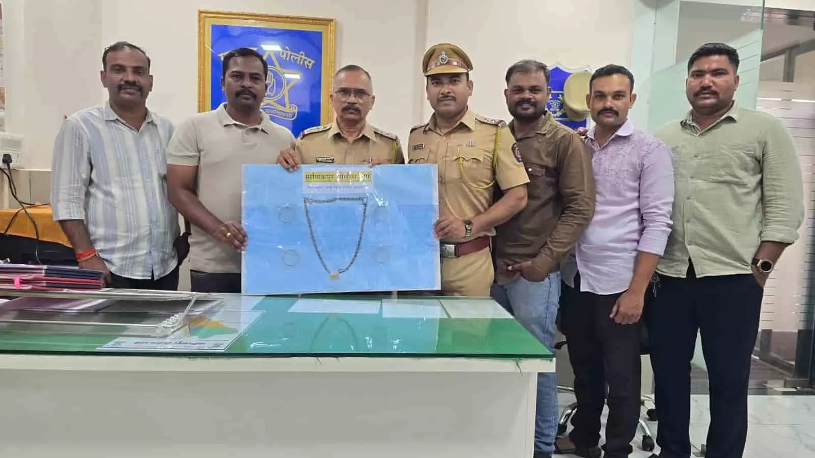 मानिकपुर पुलिस स्टेशन में पुलिस अधिकारियों के साथ खड़े लोग और टेबल पर बरामद किए गए सोने के आभूषण। मानिकपुर पुलिस स्टेशन में पुलिस अधिकारियों के साथ खड़े लोग और टेबल पर बरामद किए गए सोने के आभूषण।