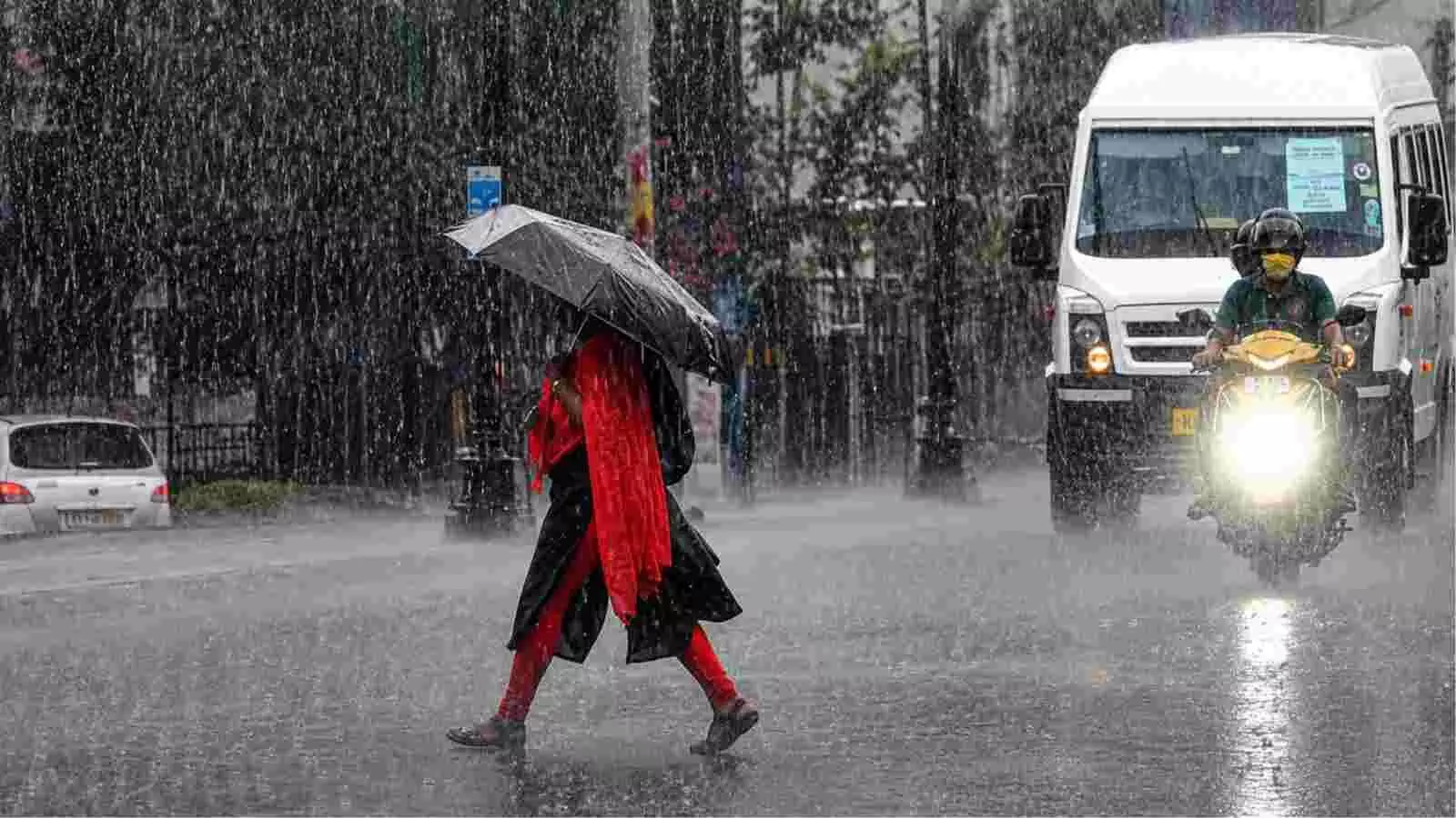 बारिश के बीच सड़क पार करती महिला और वाहन उत्तर भारत के मौसम में दर्शाए गए हैं। बारिश के बीच सड़क पार करती महिला और वाहन उत्तर भारत के मौसम में दर्शाए गए हैं।