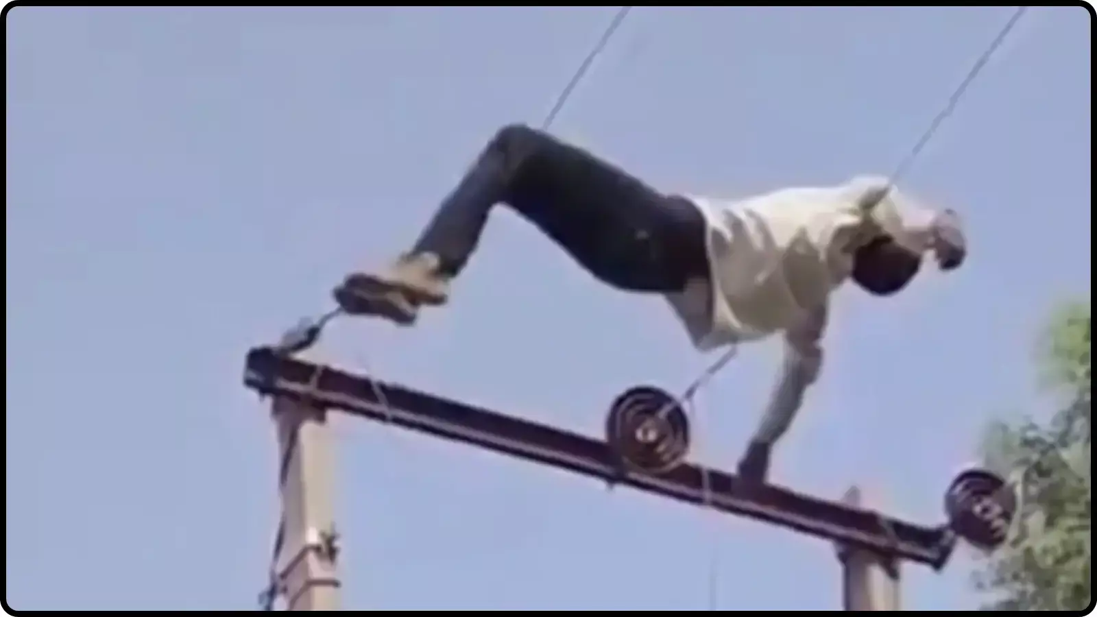 बिजली के खंभे और तारों के बीच लेटा हुआ एक युवक महाराजगंज में हाईटेंशन लाइन पर चढ़ने के संदर्भ में दिख रहा है। बिजली के खंभे और तारों के बीच लेटा हुआ एक युवक महाराजगंज में हाईटेंशन लाइन पर चढ़ने के संदर्भ में दिख रहा है।