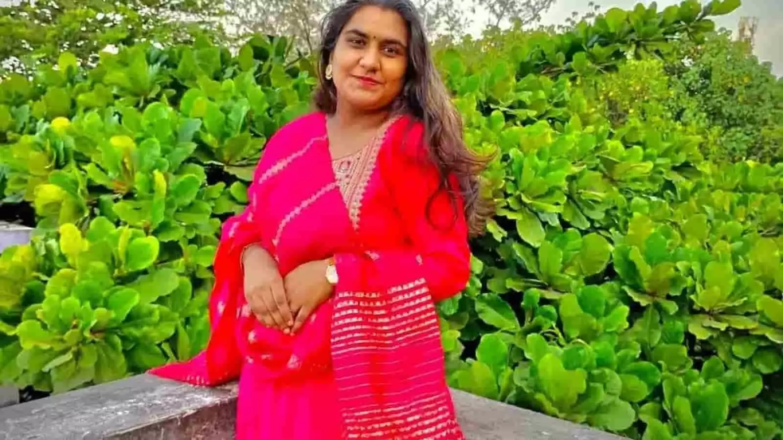 हरे भरे पौधों के सामने खड़ी गुलाबी पारंपरिक पोशाक पहने हुए मृत किशोरी श्रावणी पाटील की तस्वीर। हरे भरे पौधों के सामने खड़ी गुलाबी पारंपरिक पोशाक पहने हुए मृत किशोरी श्रावणी पाटील की तस्वीर।