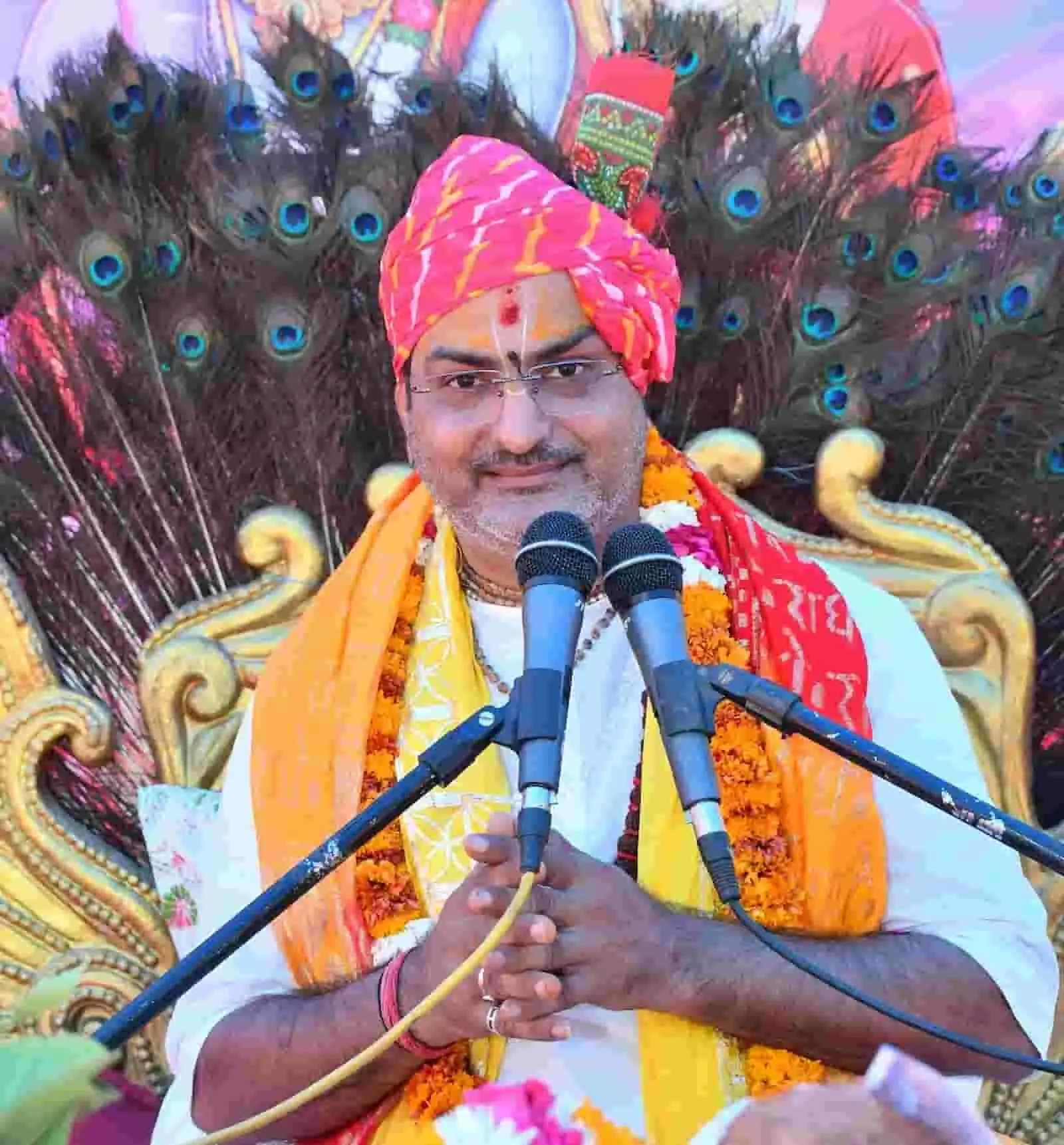 कथा मंच पर माइक के सामने हाथ जोड़कर बैठे आचार्य अशोक दीक्षित धार्मिक प्रवचन के दौरान। कथा मंच पर माइक के सामने हाथ जोड़कर बैठे आचार्य अशोक दीक्षित धार्मिक प्रवचन के दौरान।