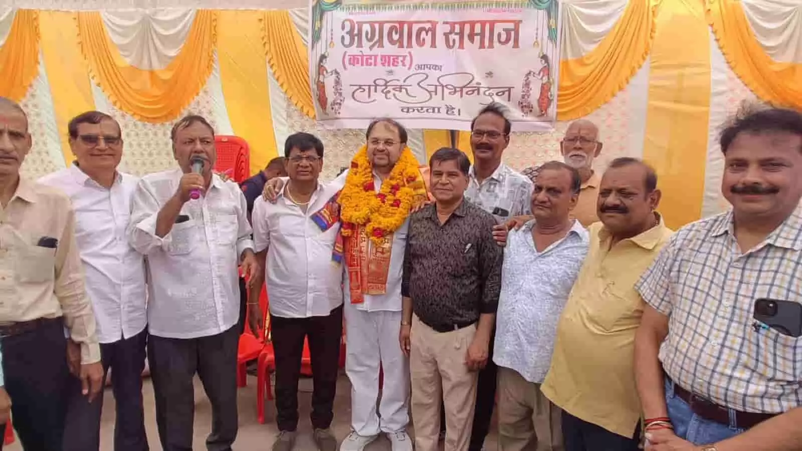 फूलों की माला पहने एक व्यक्ति और अन्य लोग कोटा में अग्रवाल समाज के कार्यक्रम के दौरान। फूलों की माला पहने एक व्यक्ति और अन्य लोग कोटा में अग्रवाल समाज के कार्यक्रम के दौरान।