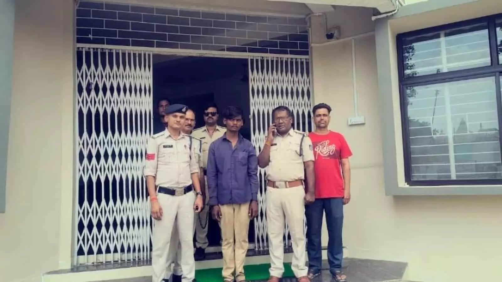 उमरियापान पुलिस स्टेशन के बाहर पुलिसकर्मियों की गिरफ्त में खड़ा एक युवक। उमरियापान पुलिस स्टेशन के बाहर पुलिसकर्मियों की गिरफ्त में खड़ा एक युवक।
