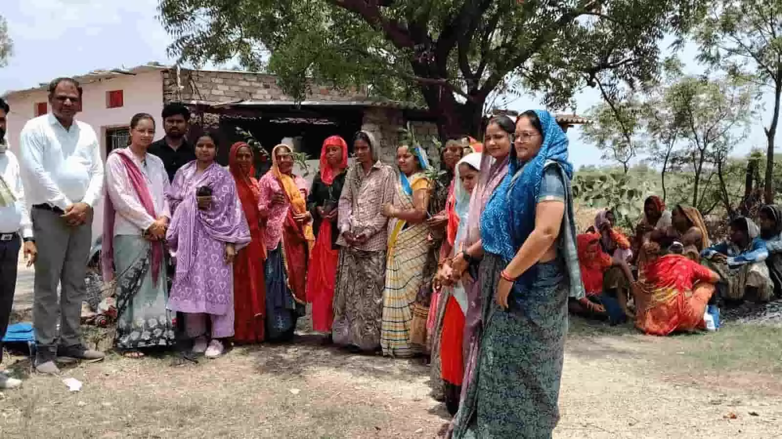 आकोला में ग्रामीण महिलाओं और पुरुषों का समूह वृक्षारोपण और खेल कार्यक्रम के दौरान।