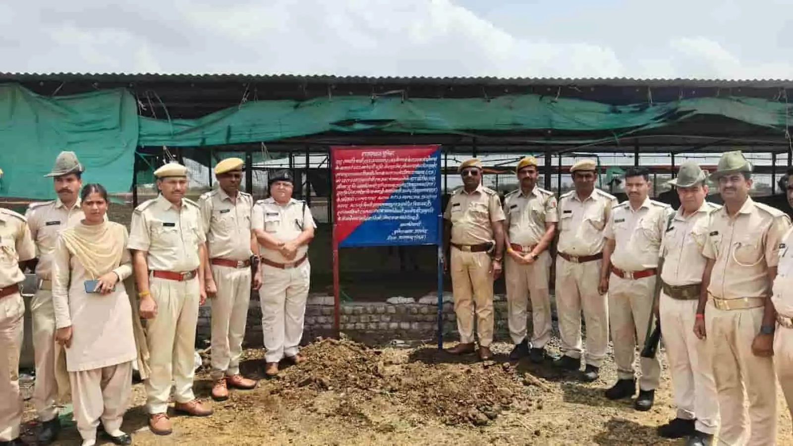 प्रतापगढ़ पुलिस अधिकारी कुर्क की गई संपत्ति के सामने खड़े दिखाई दे रहे हैं।
