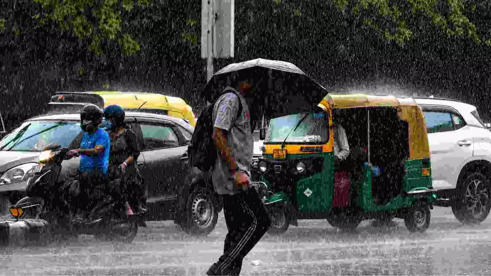 भारी बारिश के दौरान दिल्ली की सड़कों पर छाता लिए पैदल यात्री और वाहनों की आवाजाही। भारी बारिश के दौरान दिल्ली की सड़कों पर छाता लिए पैदल यात्री और वाहनों की आवाजाही।