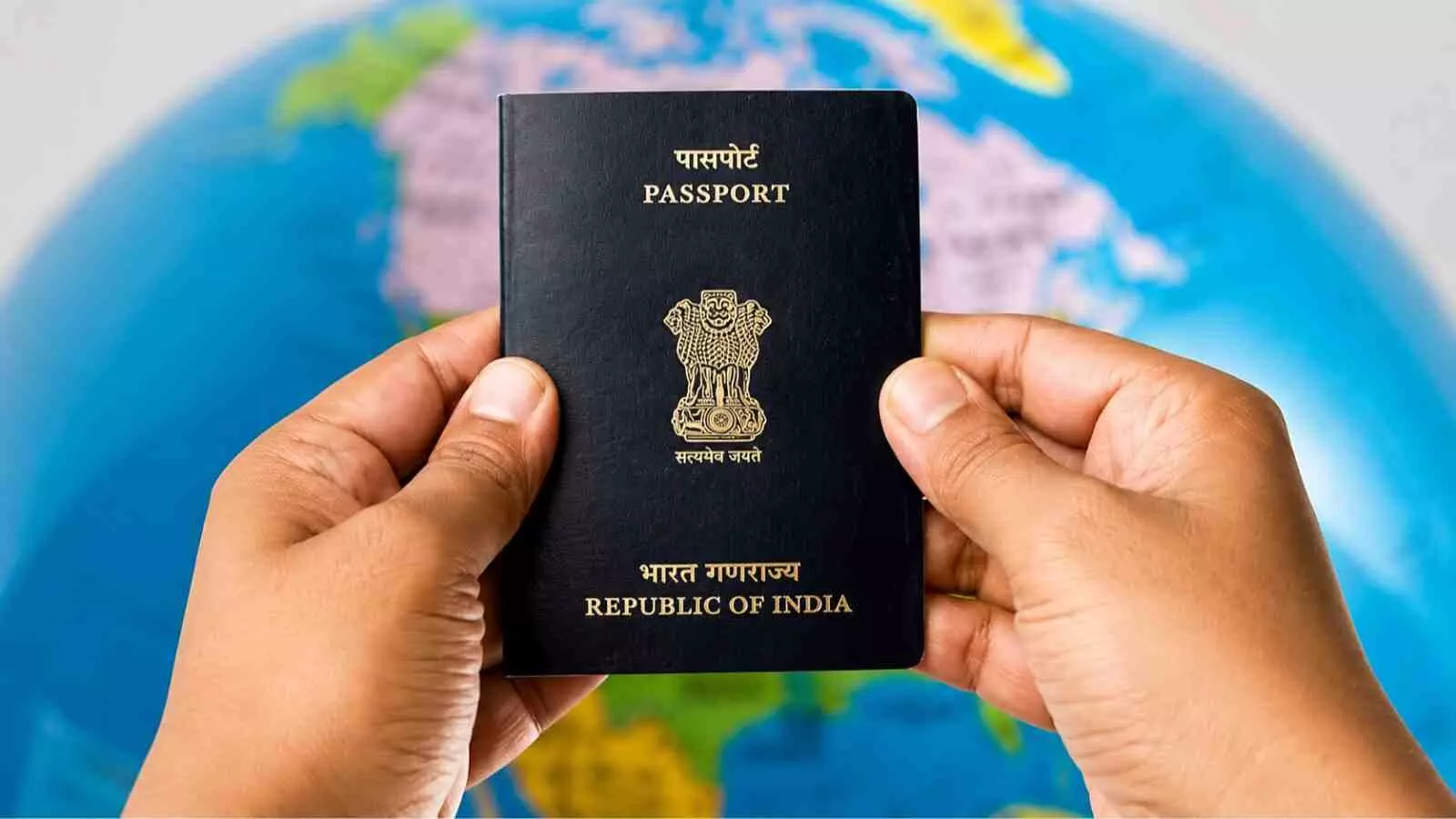 हाथ में भारतीय पासपोर्ट पकड़े हुए व्यक्ति का सांकेतिक दृश्य दिखा रहा है।