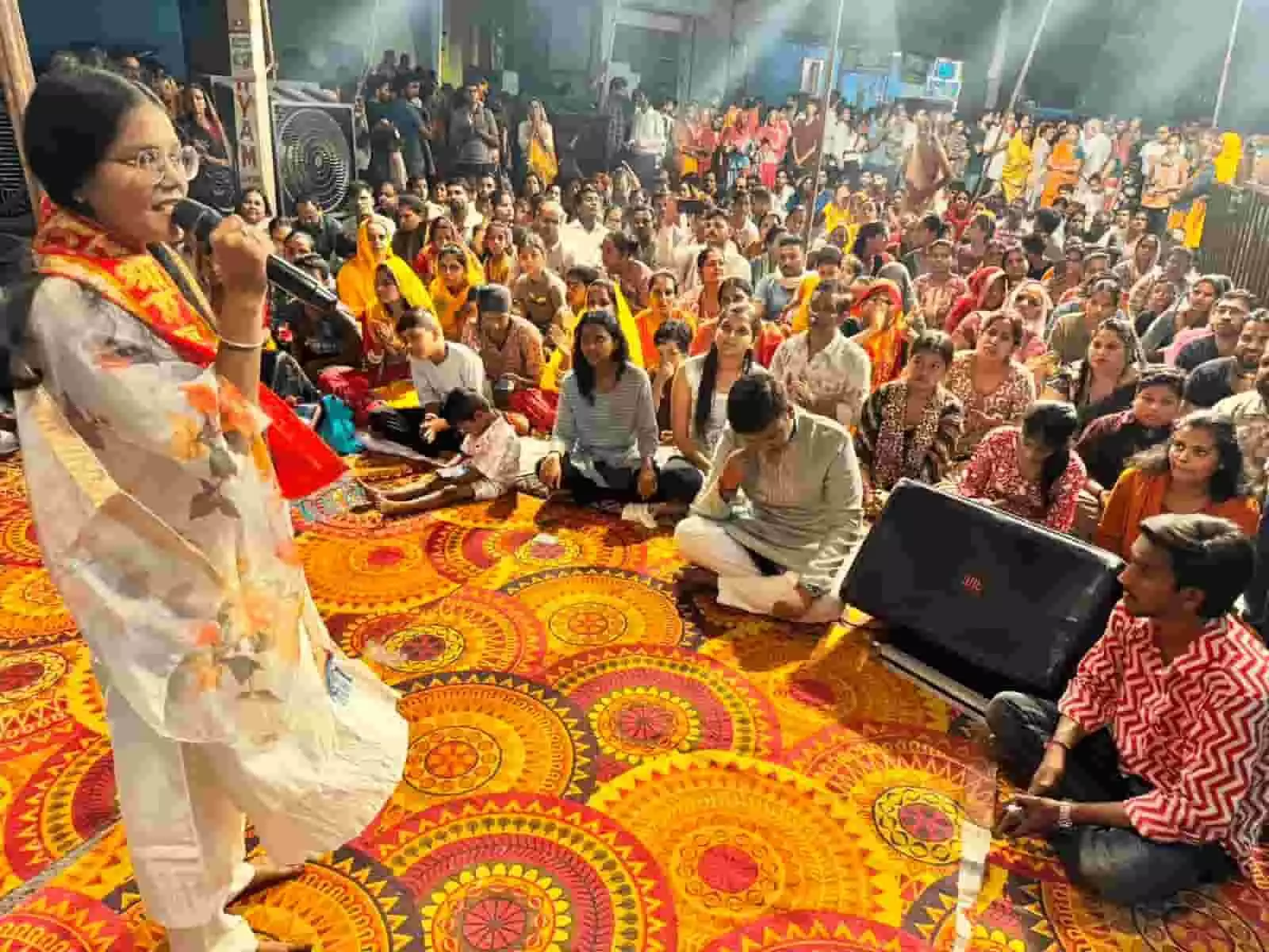 : एक महिला कलाकार भीलवाड़ा के मंदिर परिसर में श्रद्धालुओं के सामने भजन गा रही है।