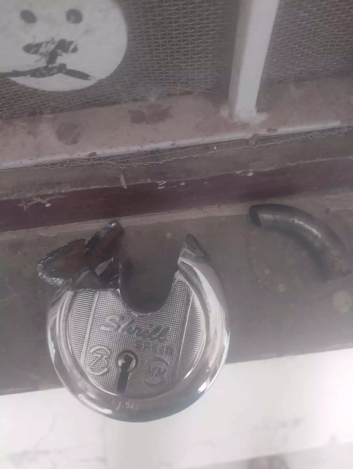 मगवास गांव में मकान के दरवाजे पर लगा टूटा हुआ ताला दिख रहा है।