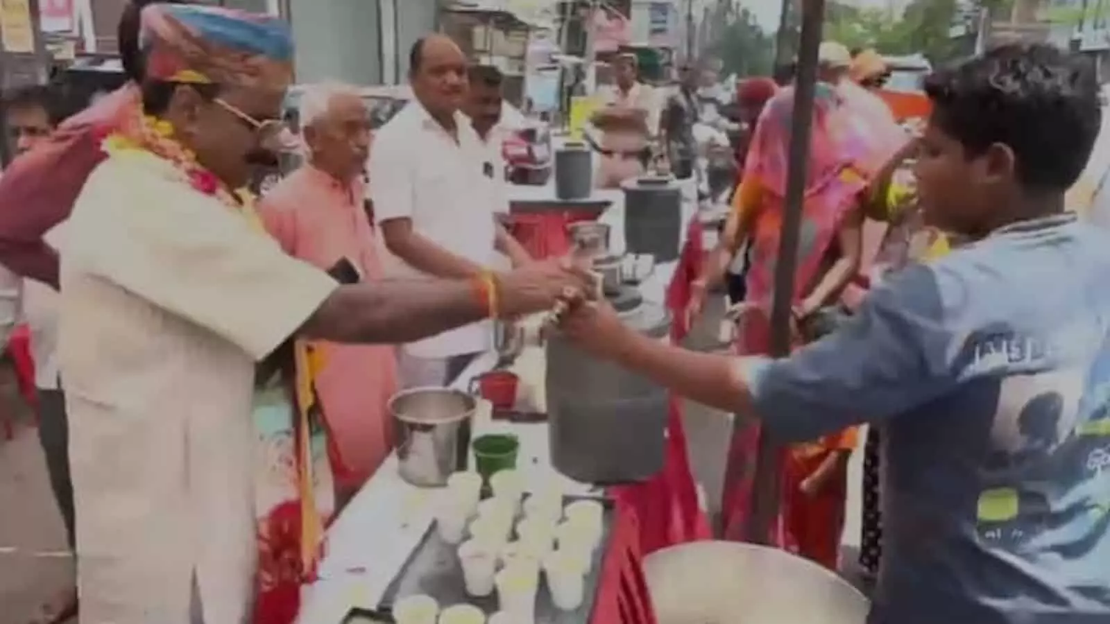 चैन सिंह राठौड़ कोटा में मंदिर परिसर में श्रद्धालुओं को ठंडाई बांट रहे हैं।