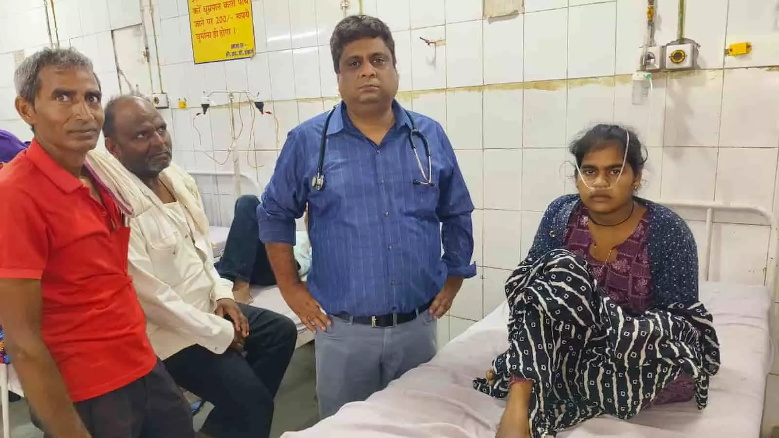 उपजिला अस्पताल में बेड पर बैठी युवती के साथ डॉक्टर और परिजन मौजूद हैं।