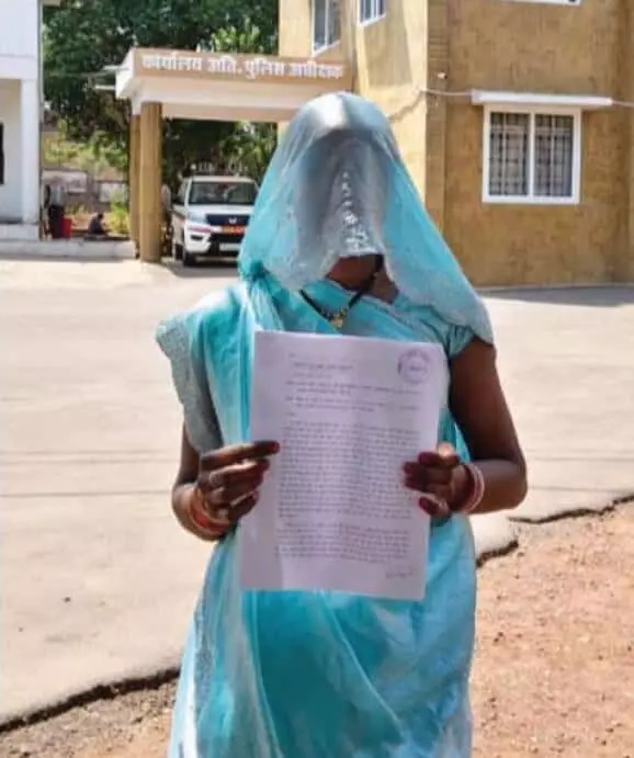 कटनी स्थित पुलिस अधीक्षक कार्यालय के बाहर हाथ में लिखित शिकायत लिए खड़ी महिला। कटनी स्थित पुलिस अधीक्षक कार्यालय के बाहर हाथ में लिखित शिकायत लिए खड़ी महिला।