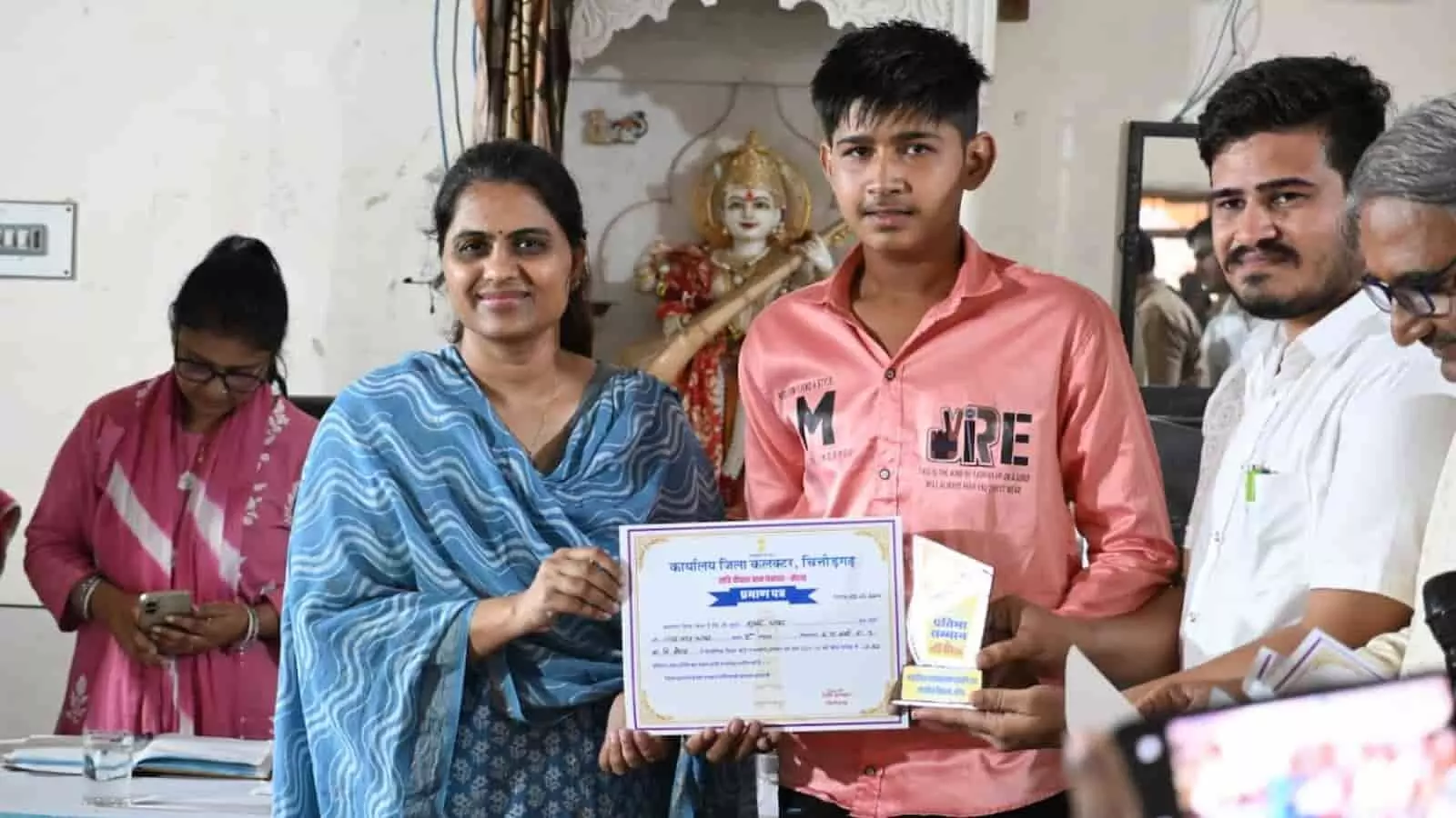 जिला कलक्टर बोराव में एक छात्र को प्रमाण पत्र प्रदान कर रही हैं।
