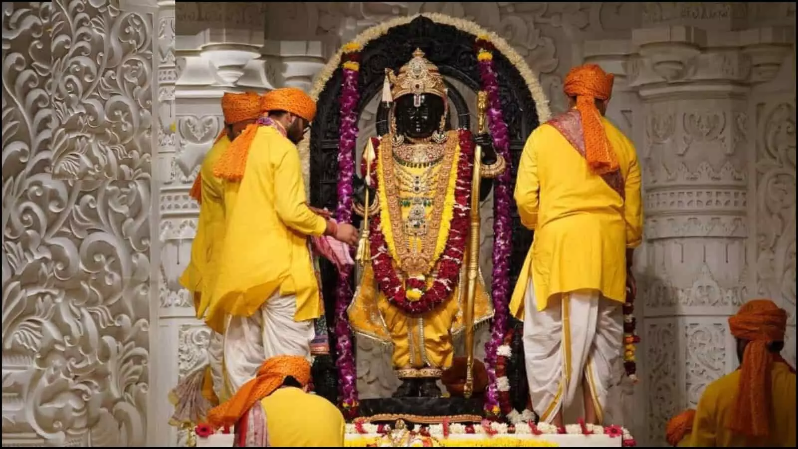 गर्भगृह में खड़ी रामलला की मूर्ति और पीले वस्त्र पहने पुजारी अयोध्या में धार्मिक अनुष्ठान के संदर्भ में।