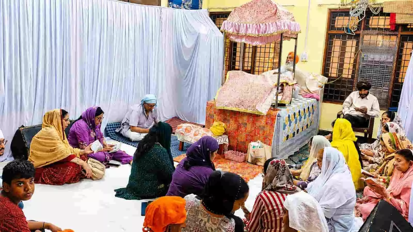 चित्तौड़गढ़ में गुरु ग्रंथ साहिब के समक्ष बैठकर श्रद्धालु अखंड पाठ कर रहे हैं।