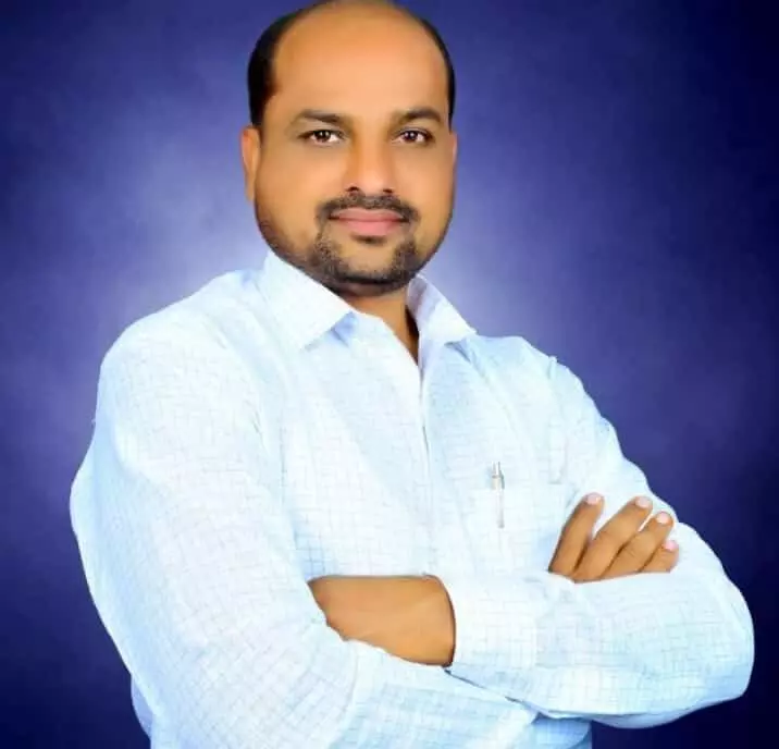 तस्वीर में भाजपा शहराध्यक्ष अमोल आसेकर नीली पृष्ठभूमि के सामने खड़े हैं।