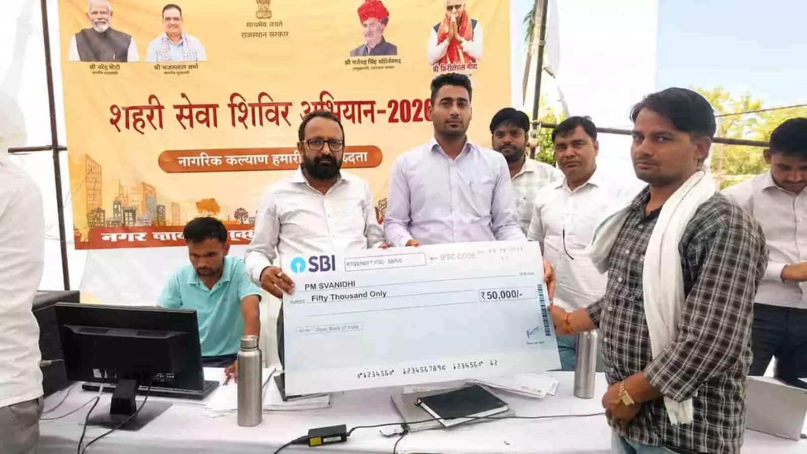 सवाई माधोपुर शिविर में अधिकारी शिवप्रकाश मीना को पीएम स्वनिधि का चेक दे रहे हैं।