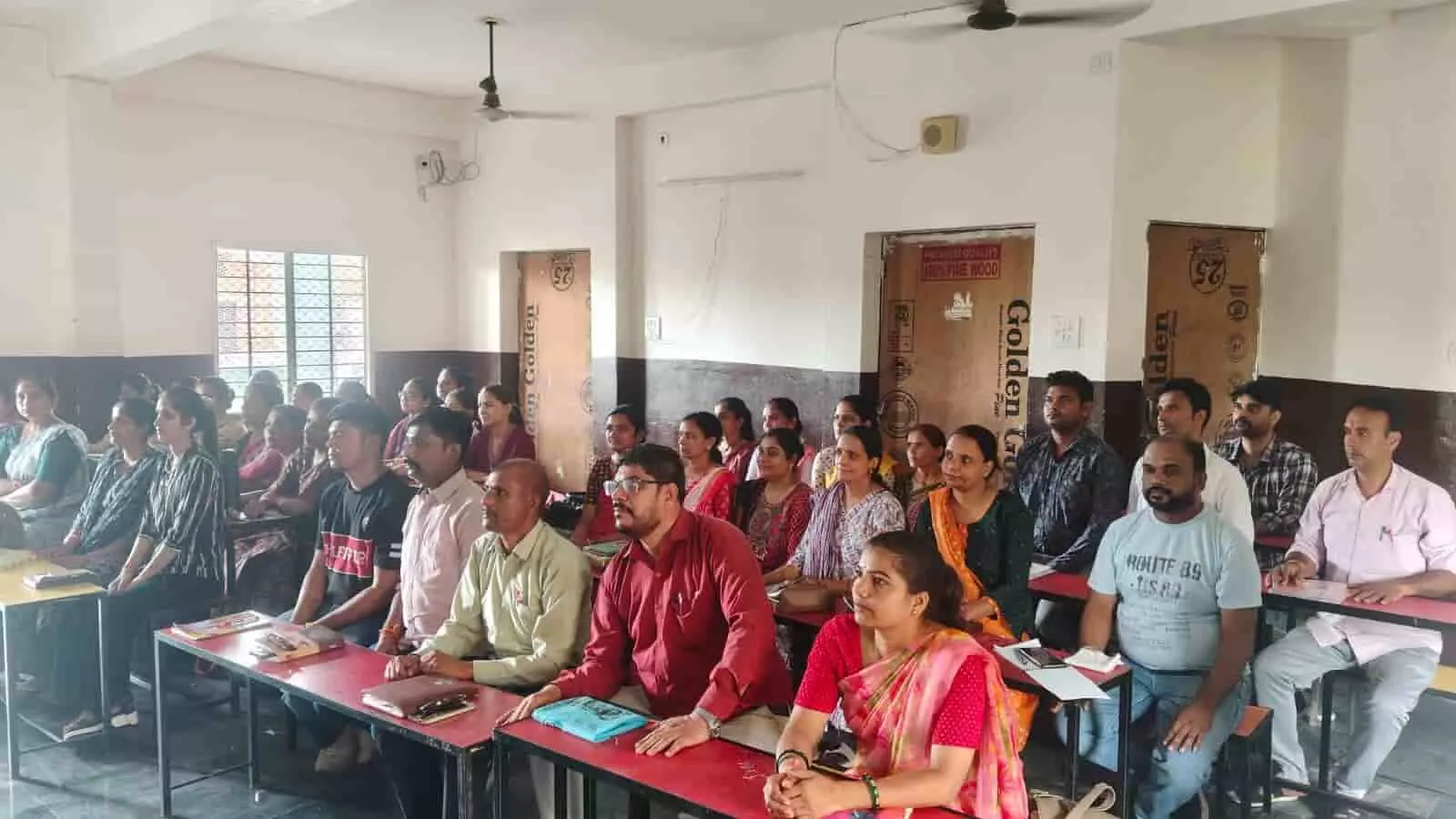 प्रशिक्षण शिविर के दौरान कक्षा में बेंच पर बैठकर ध्यानपूर्वक सुनते हुए शिक्षक और शिक्षिकाएँ। प्रशिक्षण शिविर के दौरान कक्षा में बेंच पर बैठकर ध्यानपूर्वक सुनते हुए शिक्षक और शिक्षिकाएँ।