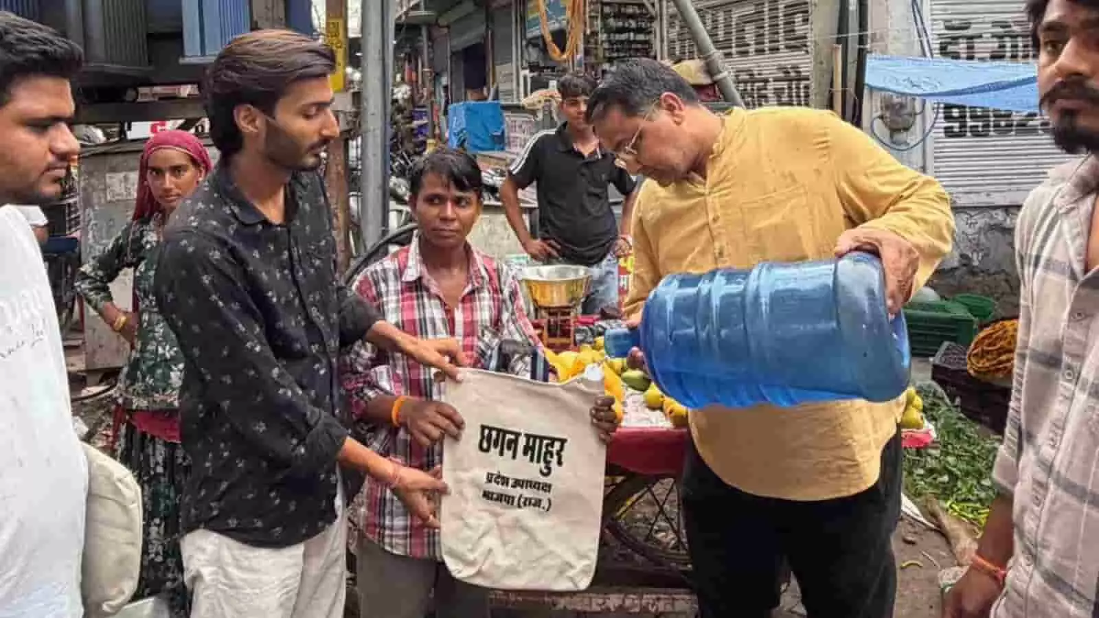 तस्वीर में भाजपा नेता छगन माँहुर कोटा में स्थानीय लोगों को पानी की केतली वितरित करते हुए।