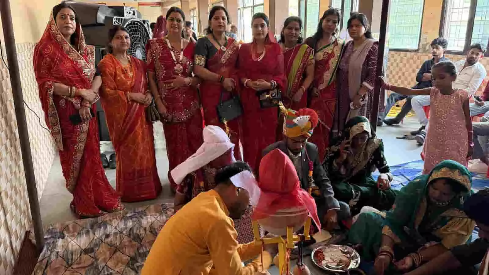 तस्वीर में सामूहिक विवाह समारोह के दौरान पारंपरिक रस्में निभाते वर-वधू और गूंज महिला मंडल के सदस्य दिख रहे हैं।