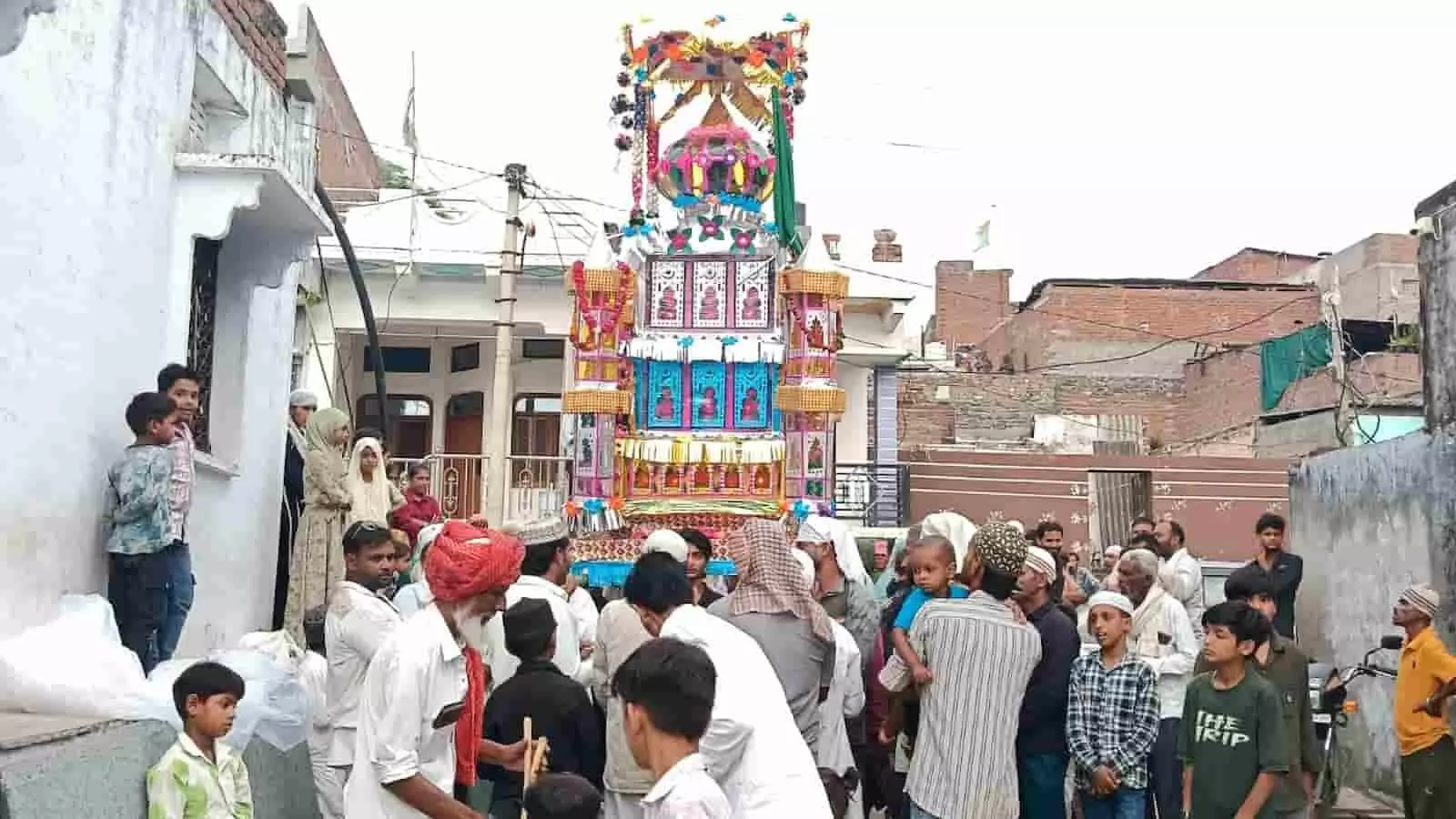 आरनी गांव की गली में मुहर्रम जुलूस के दौरान खड़े ग्रामीण और सजाया गया ताजिया। आरनी गांव की गली में मुहर्रम जुलूस के दौरान खड़े ग्रामीण और सजाया गया ताजिया।