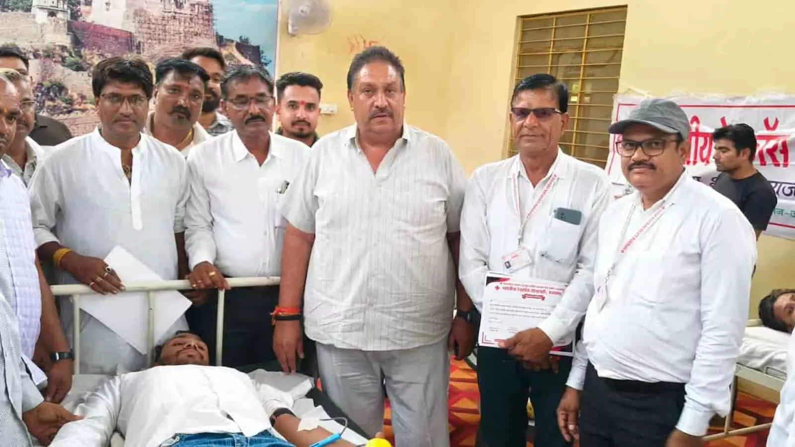 तस्वीर में आमेट के उपजिला चिकित्सालय में रक्तदान शिविर के दौरान बेड पर लेटा युवक और खड़े अन्य लोग दिख रहे हैं। तस्वीर में आमेट के उपजिला चिकित्सालय में रक्तदान शिविर के दौरान बेड पर लेटा युवक और खड़े अन्य लोग दिख रहे हैं।