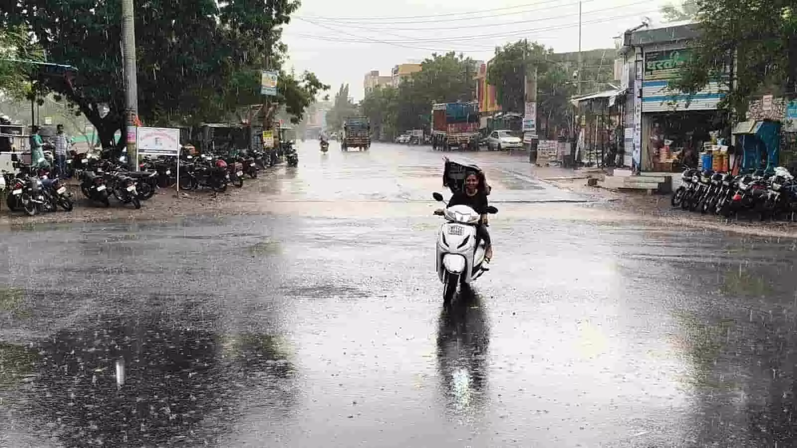 प्रतापगढ़ में बारिश के दौरान गीली सड़क पर स्कूटर चलाती महिला यात्री। प्रतापगढ़ में बारिश के दौरान गीली सड़क पर स्कूटर चलाती महिला यात्री।
