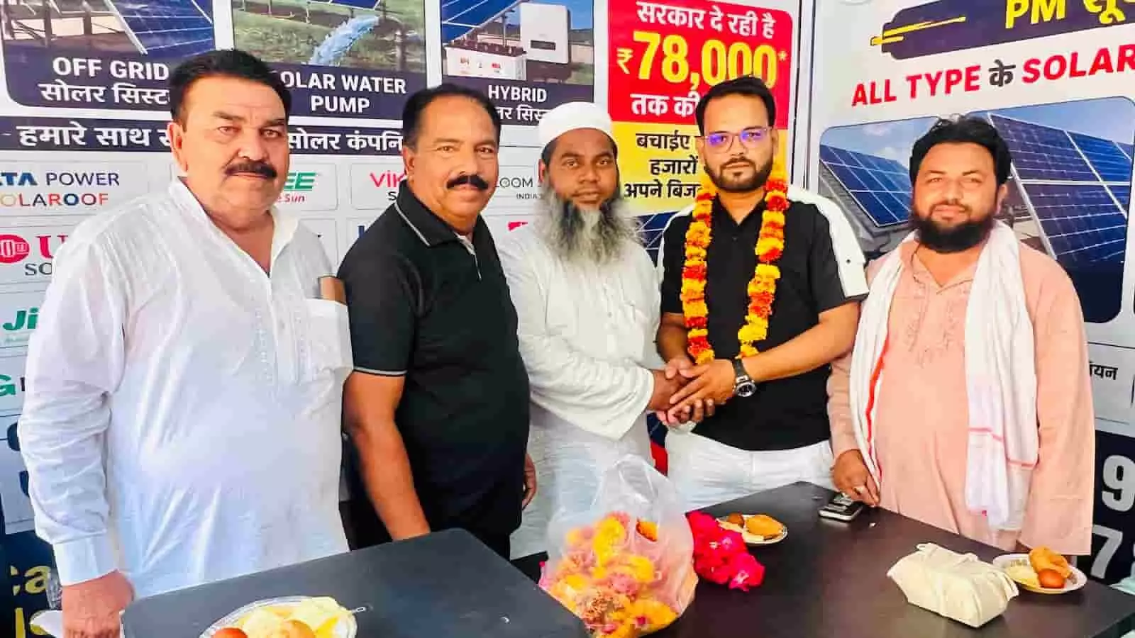 तस्वीर में टोंक के राजस्थान सोलर हाउस उद्घाटन समारोह में पांच पुरुष बैनर के सामने खड़े हैं।