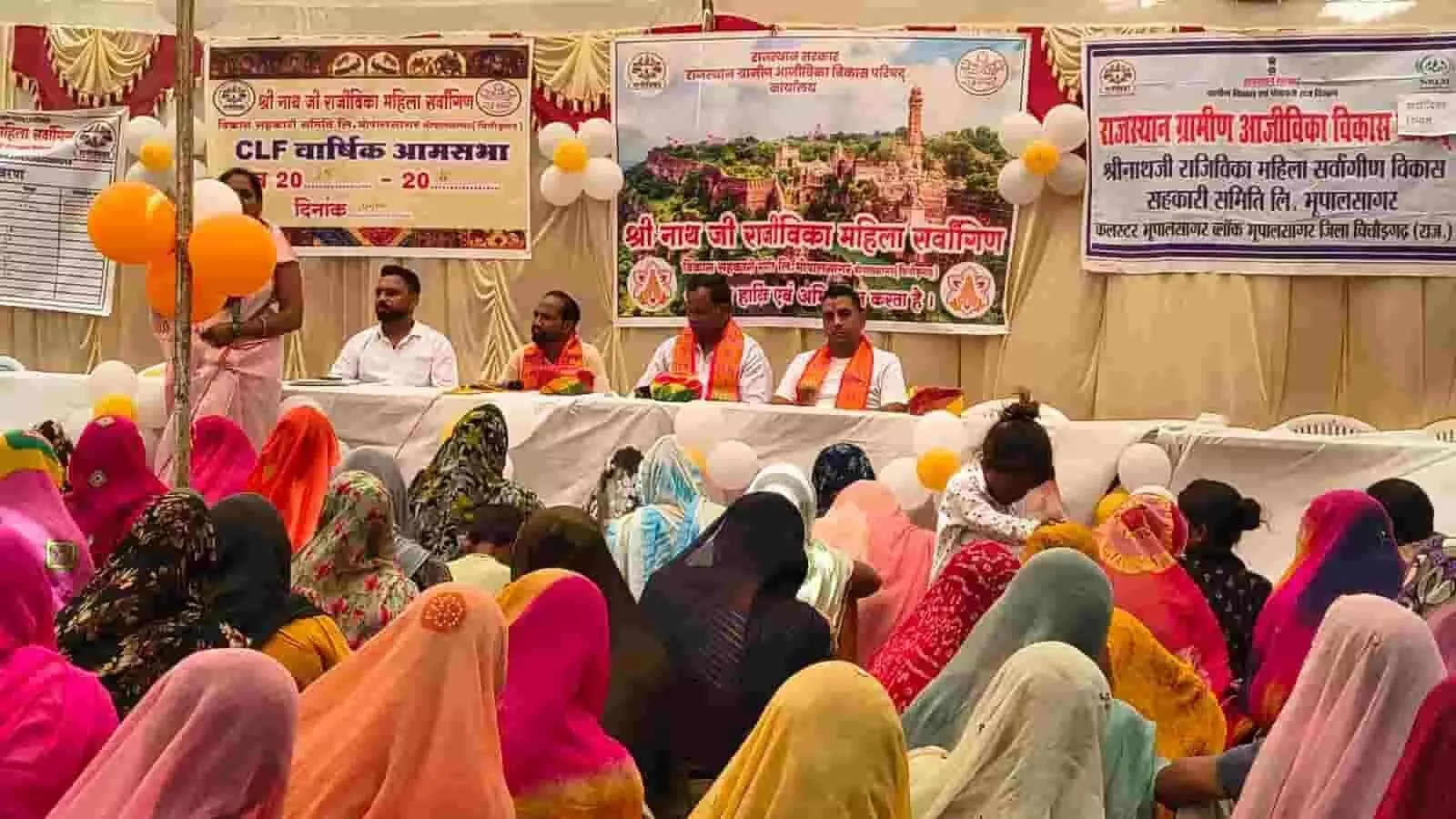 भूपालसागर में राजीविका महिला सहकारी समिति की वार्षिक आमसभा के दौरान मंच पर बैठे अतिथि और उपस्थित महिलाएं।
