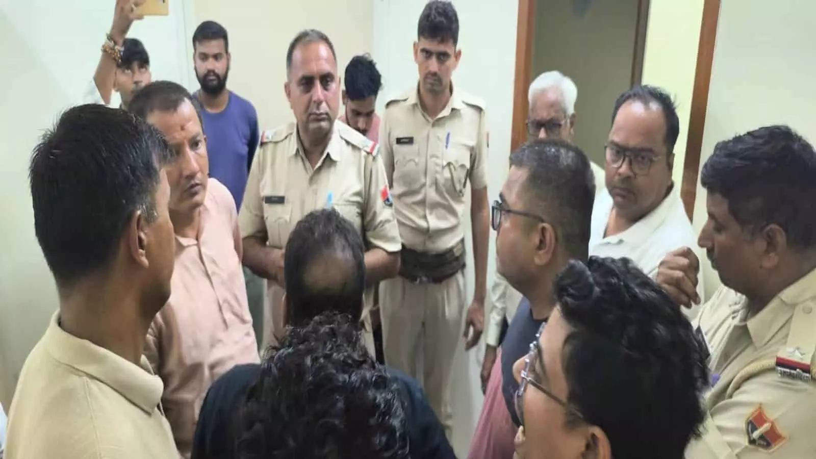 अस्पताल परिसर में हंगामे के बाद परिजन और पुलिसकर्मी बातचीत करते हुए दिख रहे हैं।