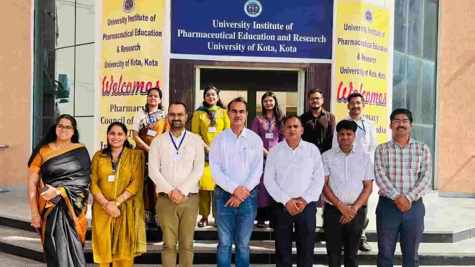 तस्वीर में कोटा विश्वविद्यालय फार्मेसी विभाग के प्रवेश द्वार पर संकाय सदस्य खड़े हैं। तस्वीर में कोटा विश्वविद्यालय फार्मेसी विभाग के प्रवेश द्वार पर संकाय सदस्य खड़े हैं।