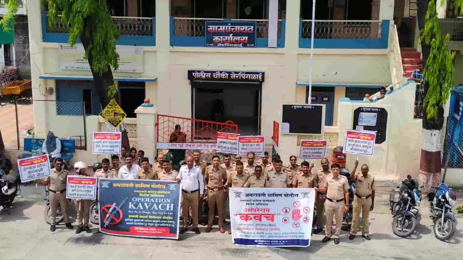 तस्वीर में अमरावती ग्रामीण पुलिस दल के जवान ग्रामपंचायत कार्यालय के बाहर ऑपरेशन कवच बैनर के साथ खड़े हैं।