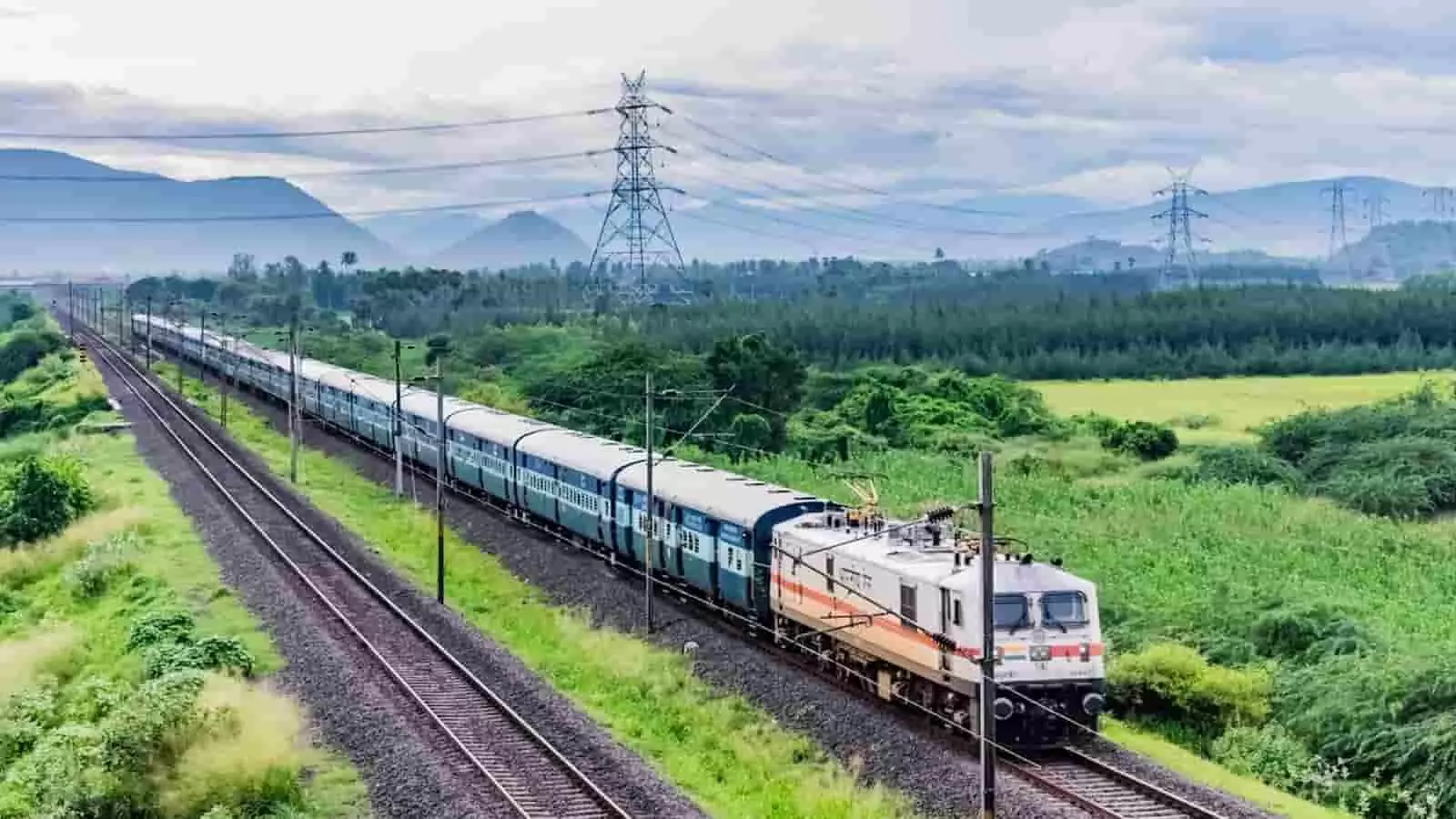 रेलवे ट्रैक पर दौड़ती हुई यात्री ट्रेन ग्रामीण इलाके में रेल सेवा के दृश्य को दर्शाती है। रेलवे ट्रैक पर दौड़ती हुई यात्री ट्रेन ग्रामीण इलाके में रेल सेवा के दृश्य को दर्शाती है।