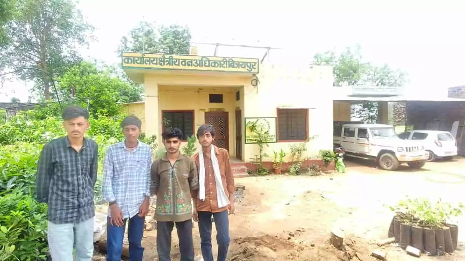 चित्तौड़गढ़ के विजयपुर क्षेत्रीय वन अधिकारी कार्यालय के बाहर खड़े चार युवक और पीछे खड़ी वन विभाग की गाड़ी।