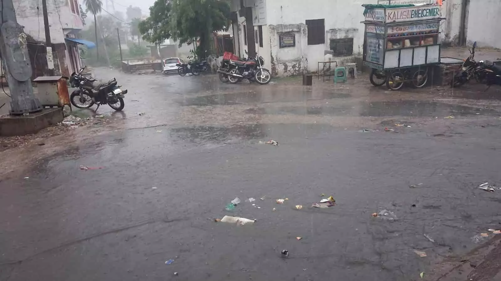 लसाड़िया की सड़क पर बारिश के दौरान खड़े वाहन और भीगी हुई जमीन दिख रही है। लसाड़िया की सड़क पर बारिश के दौरान खड़े वाहन और भीगी हुई जमीन दिख रही है।