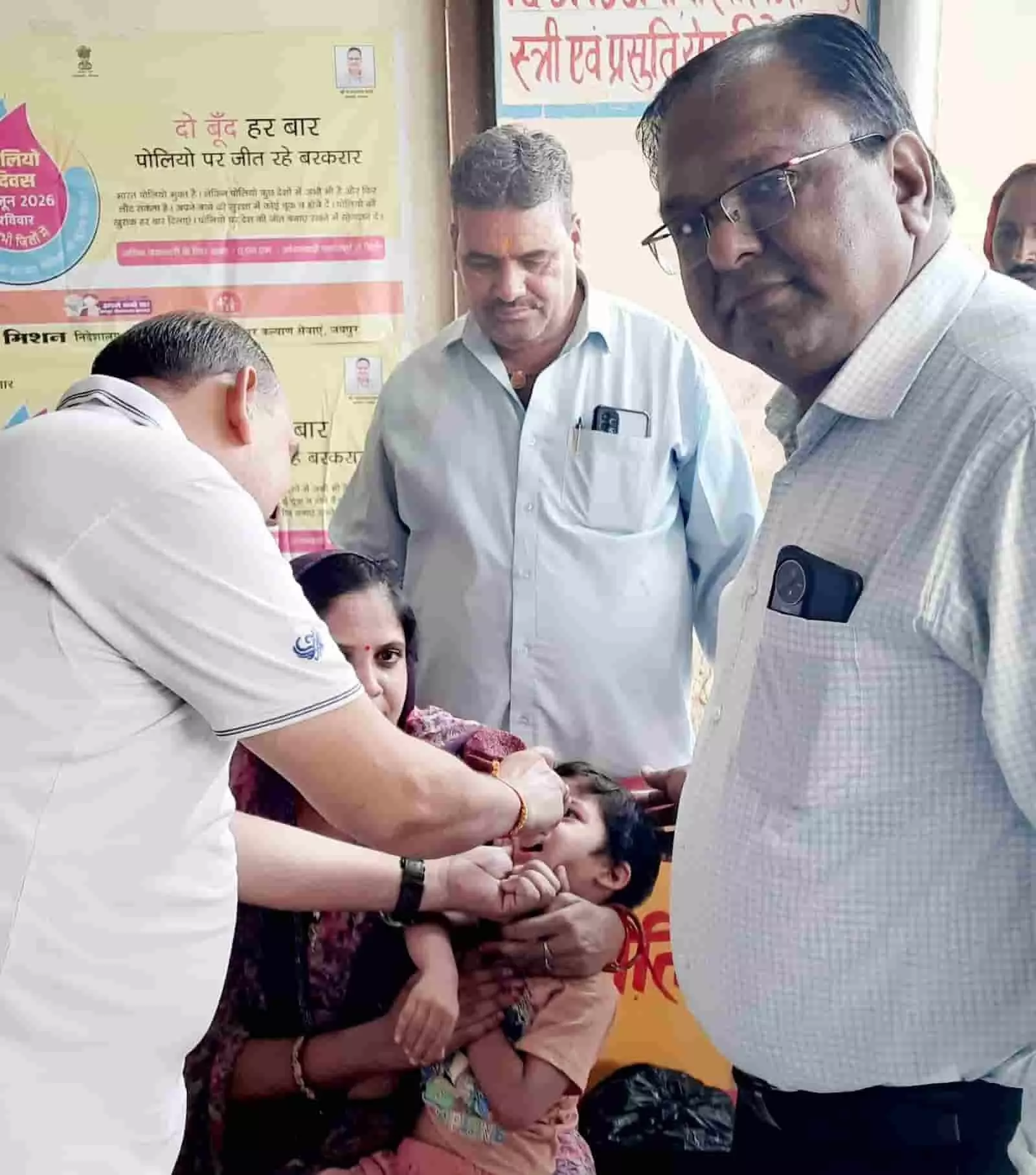 स्वास्थ्य कर्मी एक छोटे बच्चे को पोलियो की दवा पिलाते हुए दिख रहे हैं। स्वास्थ्य कर्मी एक छोटे बच्चे को पोलियो की दवा पिलाते हुए दिख रहे हैं।