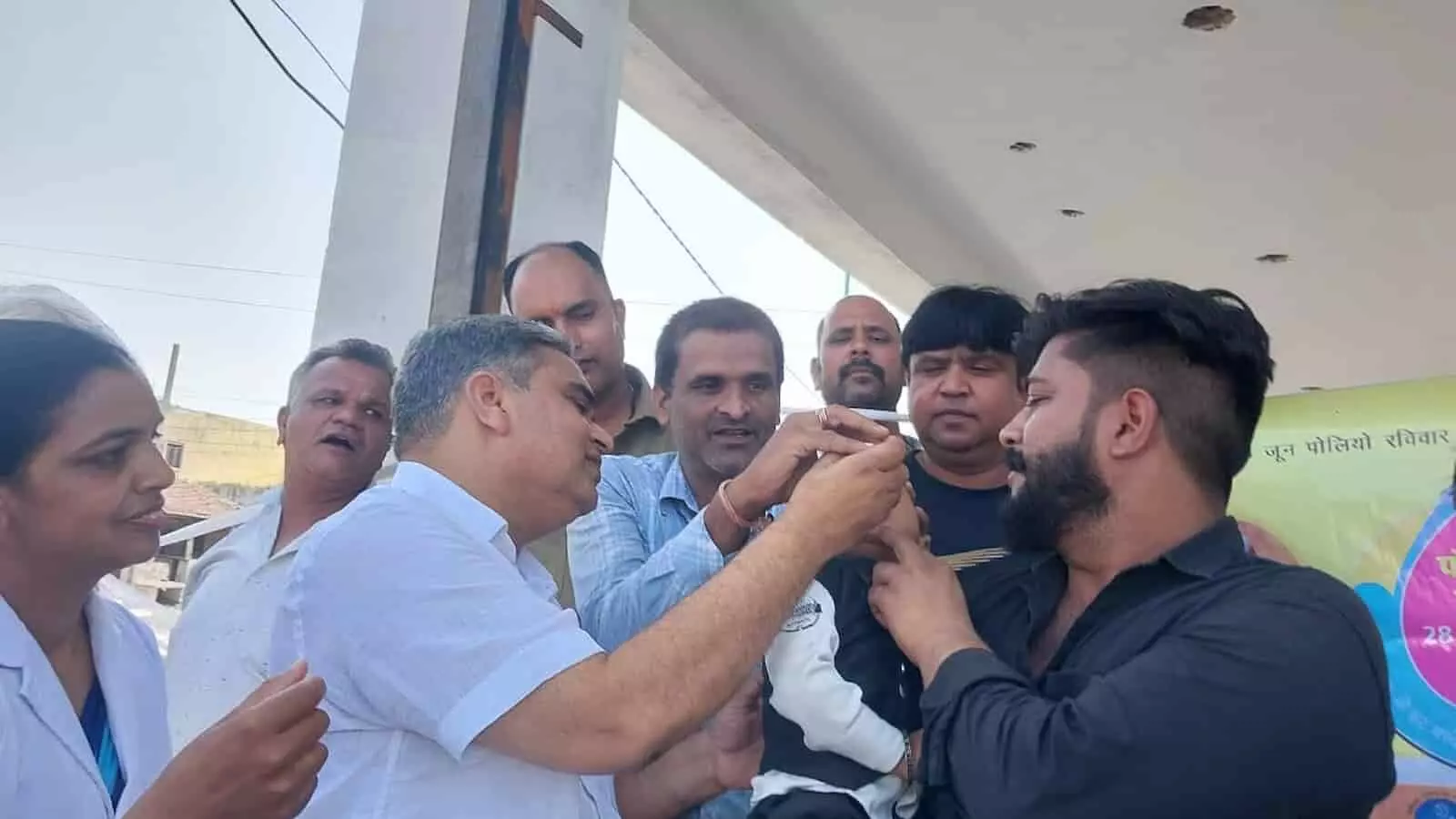 मंत्री गौतम दक डूंगला में एक बच्चे को पोलियो की दवा पिला रहे हैं।