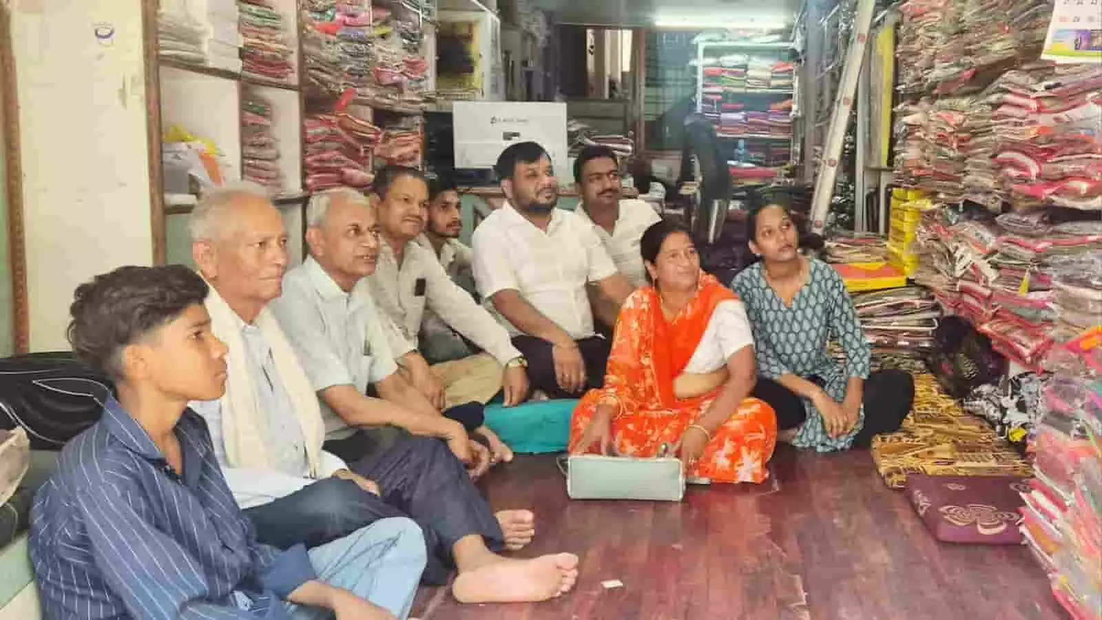 कपड़े की दुकान में फर्श पर बैठकर मन की बात कार्यक्रम देखते हुए भाजपा कार्यकर्ता। कपड़े की दुकान में फर्श पर बैठकर मन की बात कार्यक्रम देखते हुए भाजपा कार्यकर्ता।