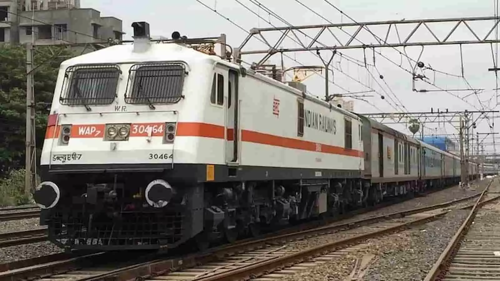 रेलवे ट्रैक पर एक इलेक्ट्रिक इंजन के साथ भारतीय ट्रेन दौड़ रही है। रेलवे ट्रैक पर एक इलेक्ट्रिक इंजन के साथ भारतीय ट्रेन दौड़ रही है।