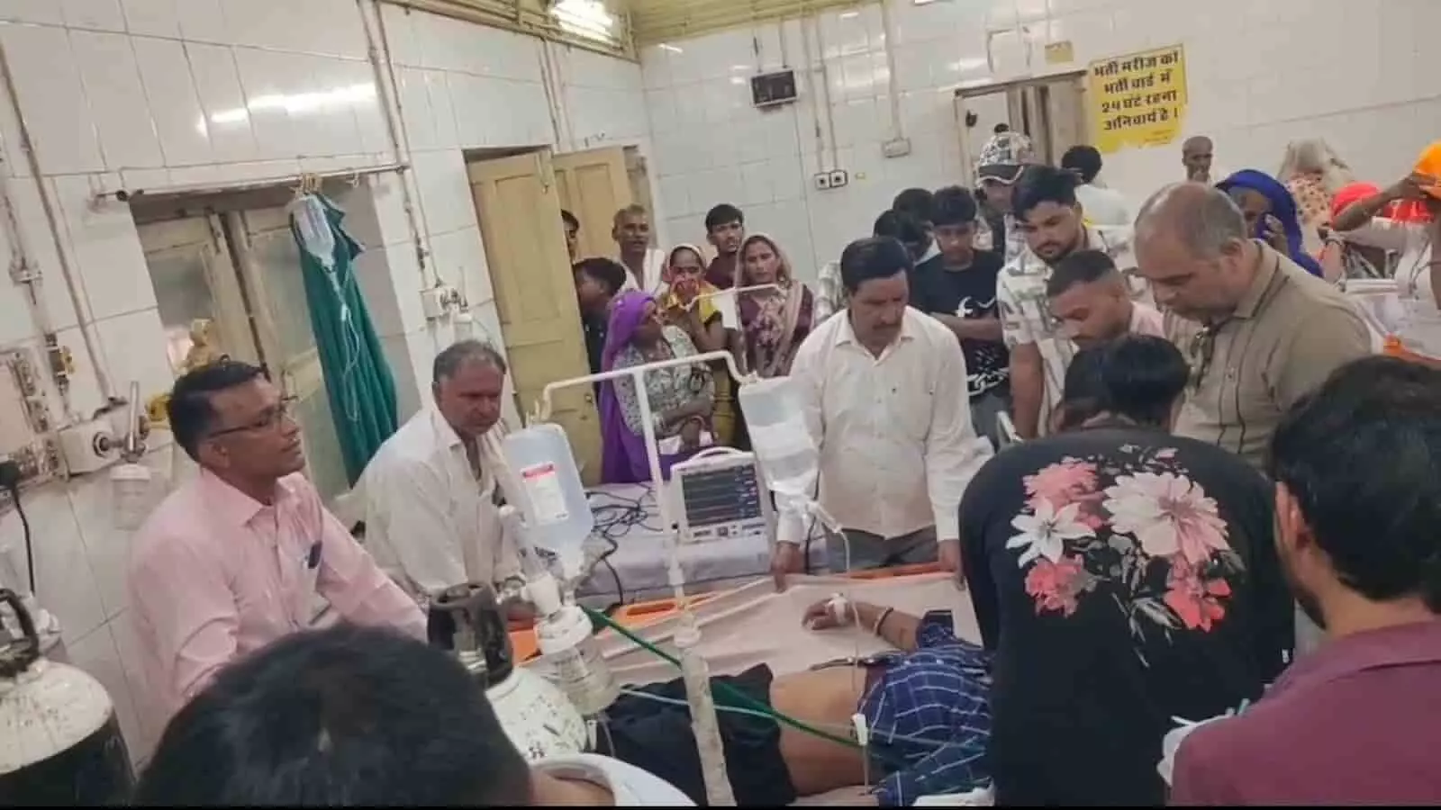 अस्पताल के इमरजेंसी वार्ड में स्ट्रेचर पर लेटे मरीज का इलाज करते डॉक्टर और मौजूद लोग। अस्पताल के इमरजेंसी वार्ड में स्ट्रेचर पर लेटे मरीज का इलाज करते डॉक्टर और मौजूद लोग।