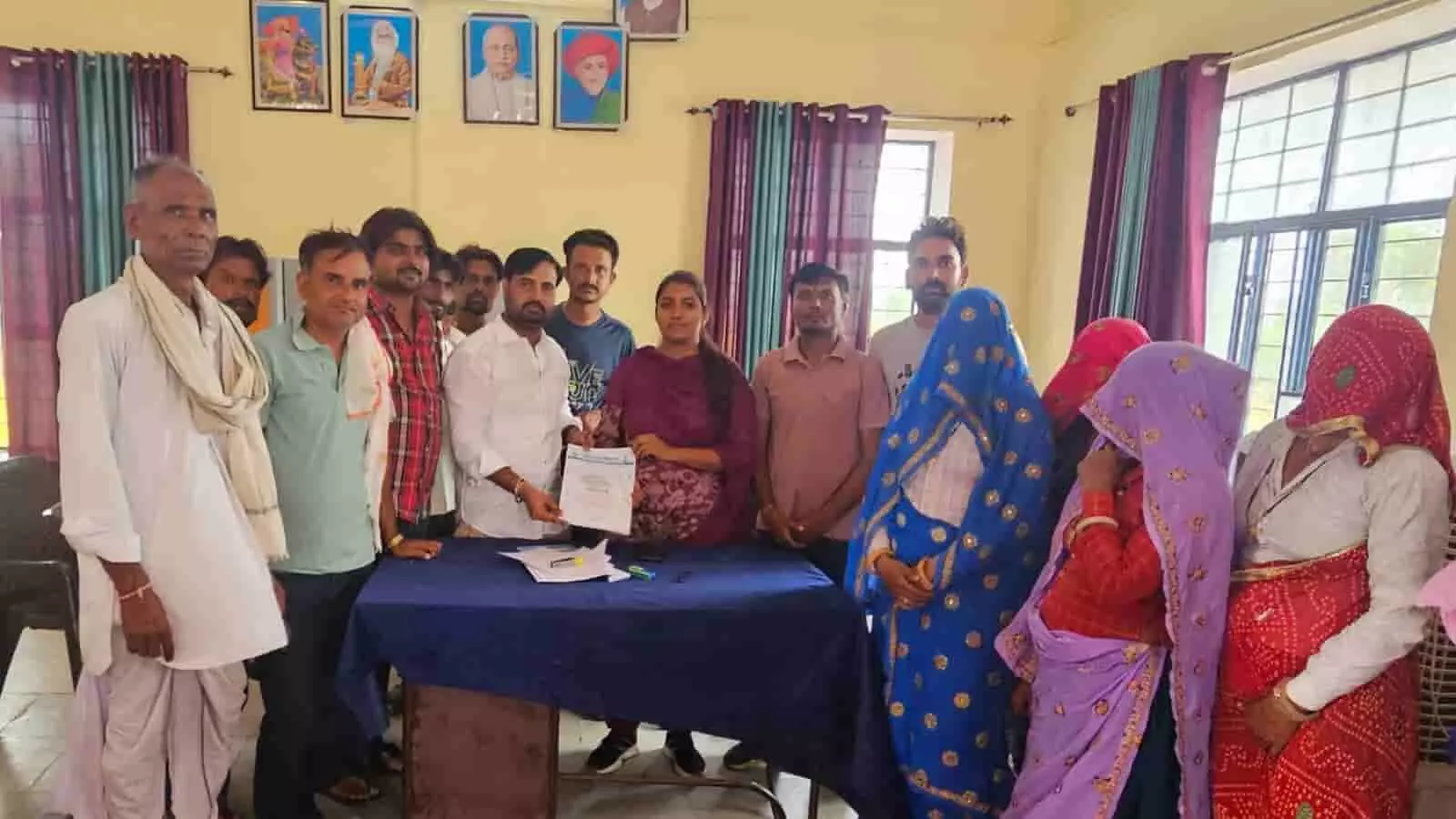 कार्यालय के कमरे में ग्राम विकास अधिकारी को लिखित ज्ञापन सौंपते ग्रामीण पुरुष और महिलाएं। कार्यालय के कमरे में ग्राम विकास अधिकारी को लिखित ज्ञापन सौंपते ग्रामीण पुरुष और महिलाएं।