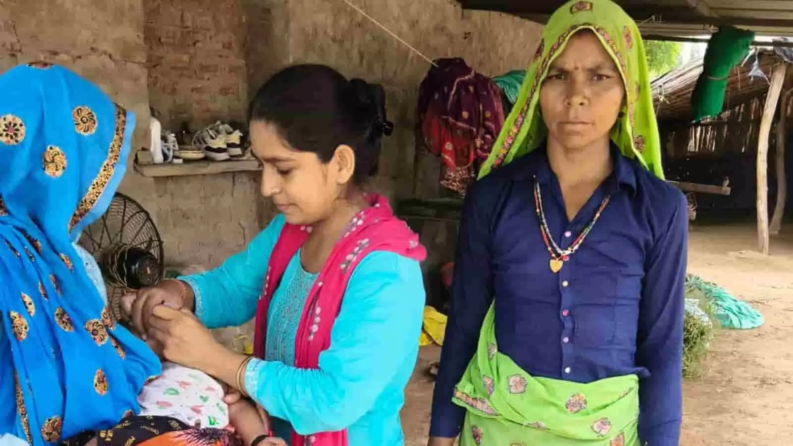 तस्वीर में एक स्वास्थ्य कार्यकर्ता घर के बाहर बच्चे को पोलियो की दवा पिलाते हुए दिख रही है। तस्वीर में एक स्वास्थ्य कार्यकर्ता घर के बाहर बच्चे को पोलियो की दवा पिलाते हुए दिख रही है।