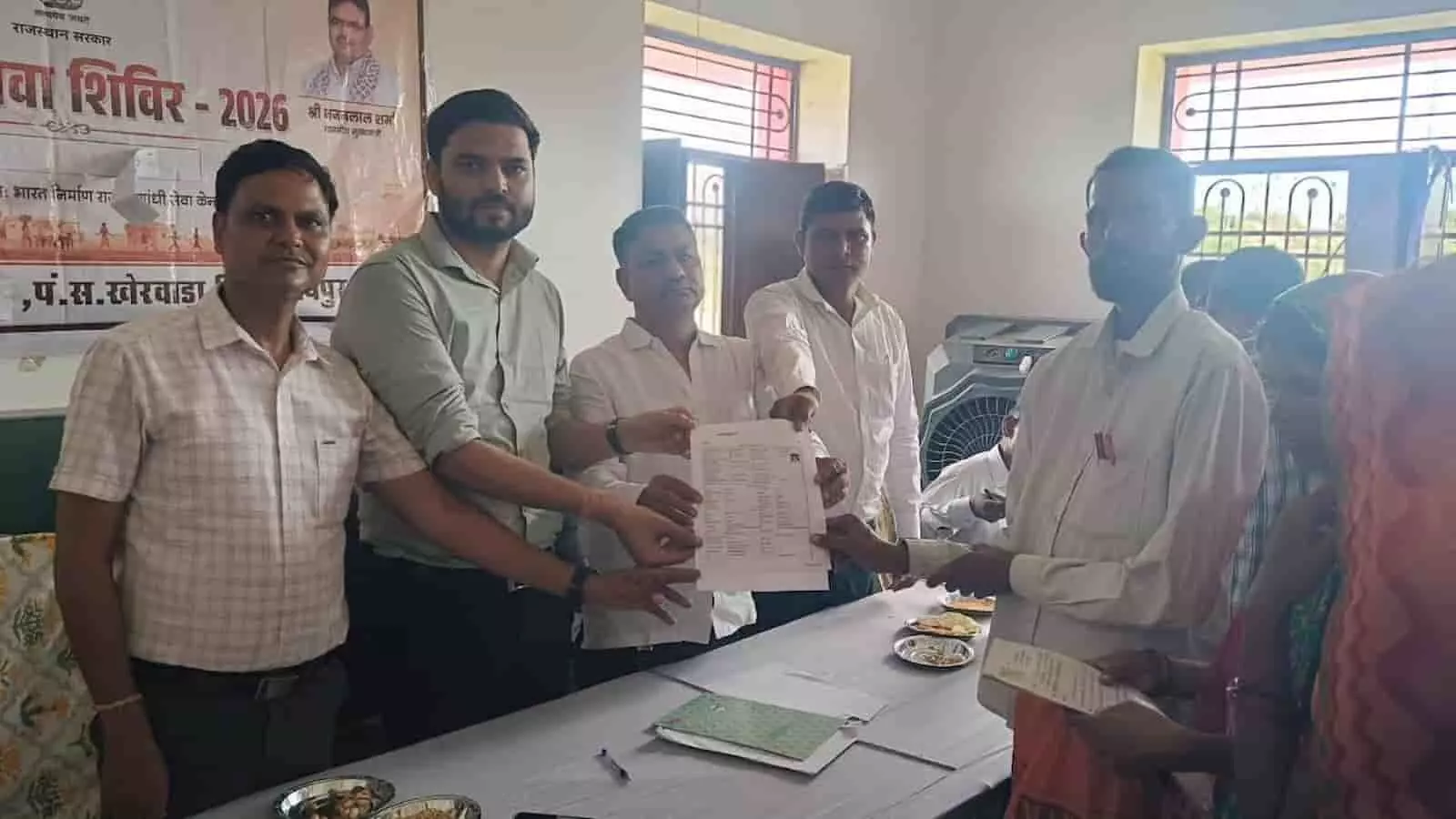 खेरवाड़ा के शिविर में अधिकारी ग्रामीण को सरकारी दस्तावेज देते हुए नजर आ रहे हैं। खेरवाड़ा के शिविर में अधिकारी ग्रामीण को सरकारी दस्तावेज देते हुए नजर आ रहे हैं।