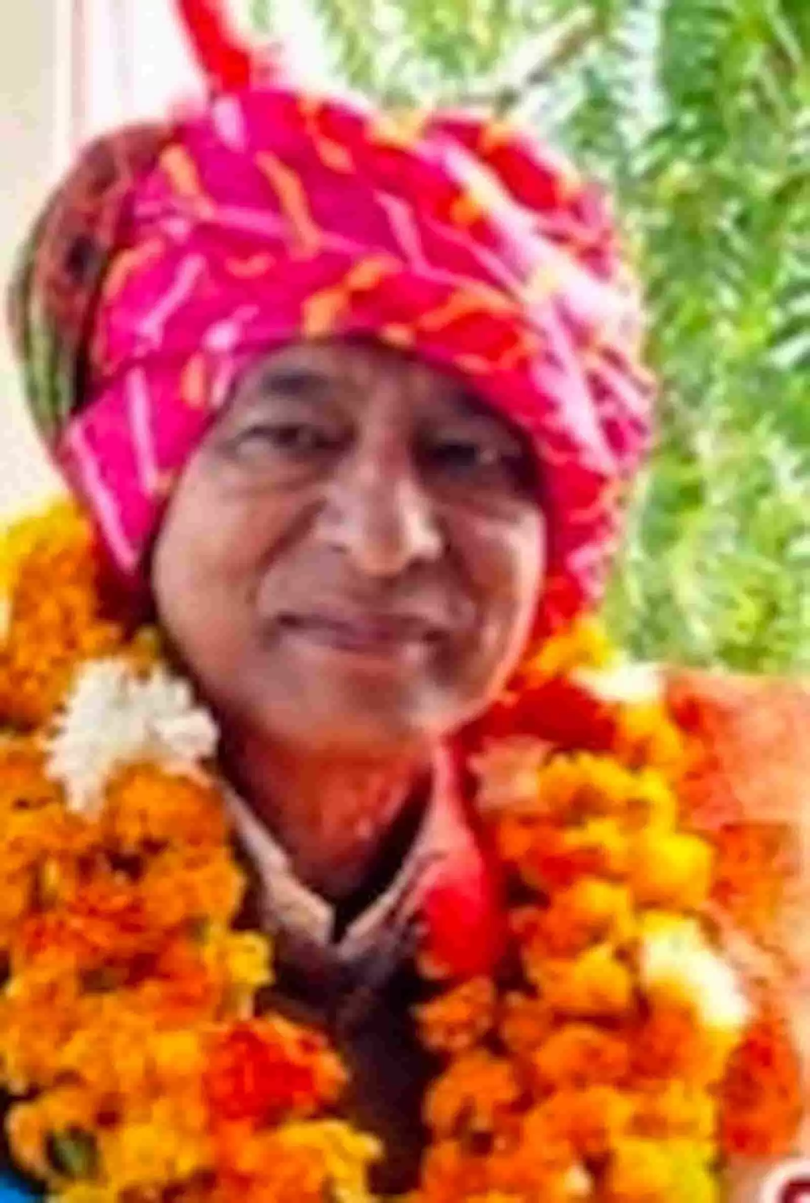 पारंपरिक राजस्थानी साफा और फूलों की माला पहने मुस्कुराते हुए पत्रकार राजेश शर्मा सवाई माधोपुर में।