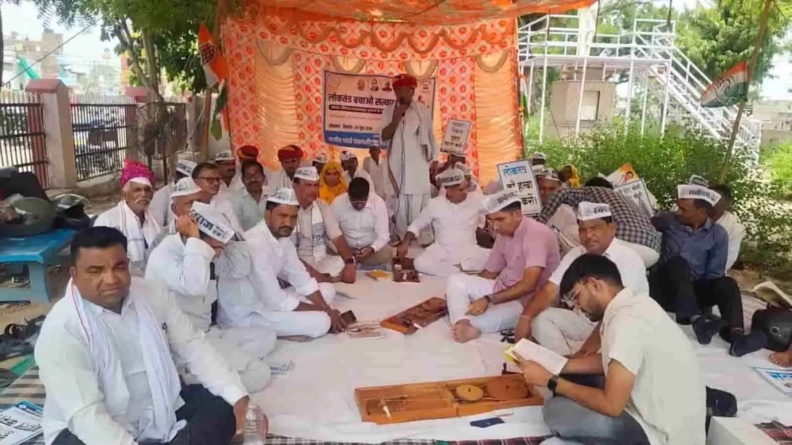 टोंक के गांधी पार्क में मंच पर बैठकर सत्याग्रह कार्यक्रम में शामिल होते हुए लोग।
