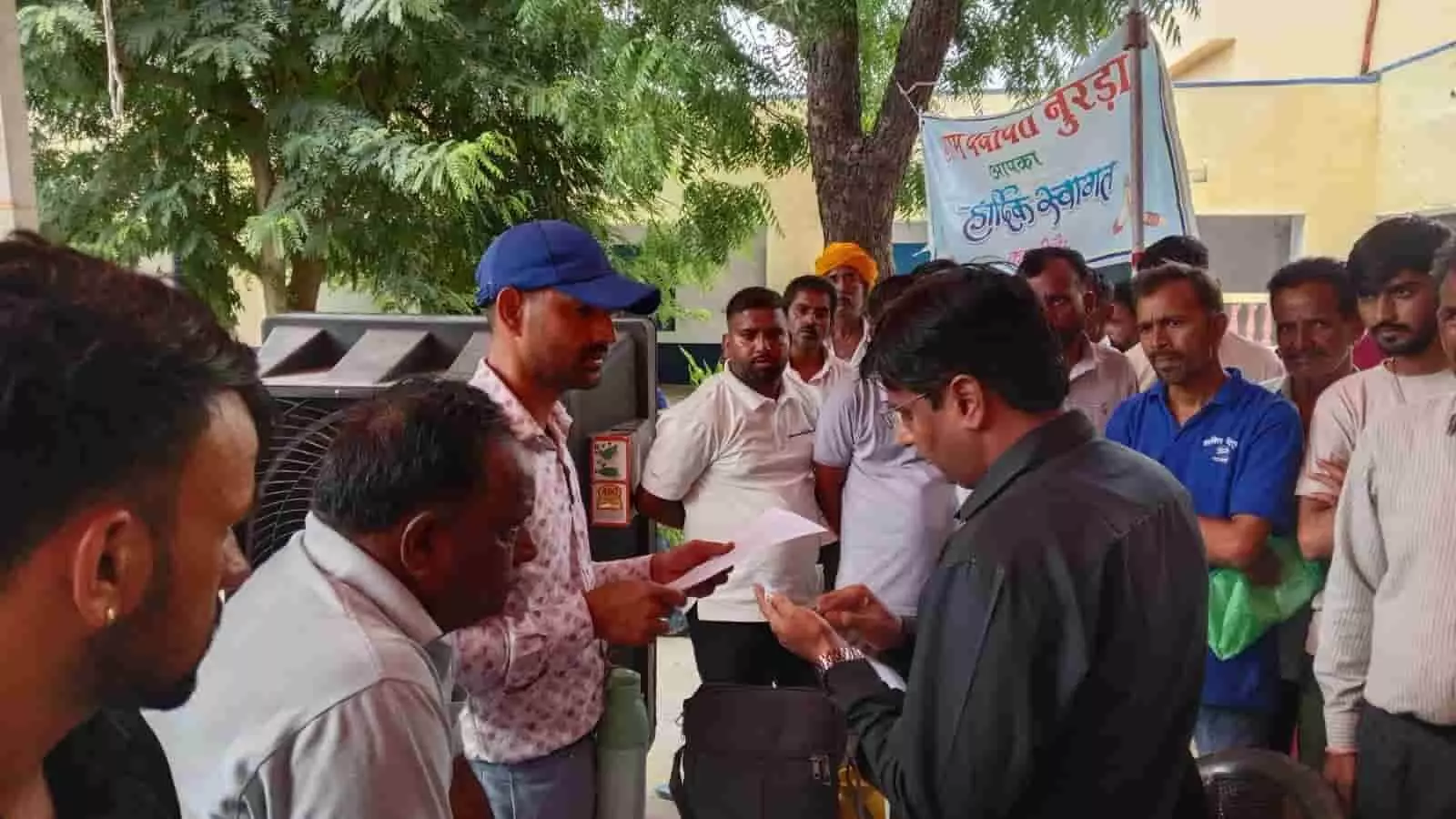 तस्वीर में नूरड़ा ग्राम पंचायत के ग्रामीण सेवा शिविर में अधिकारी लोगों से दस्तावेज लेते हुए दिख रहे हैं।