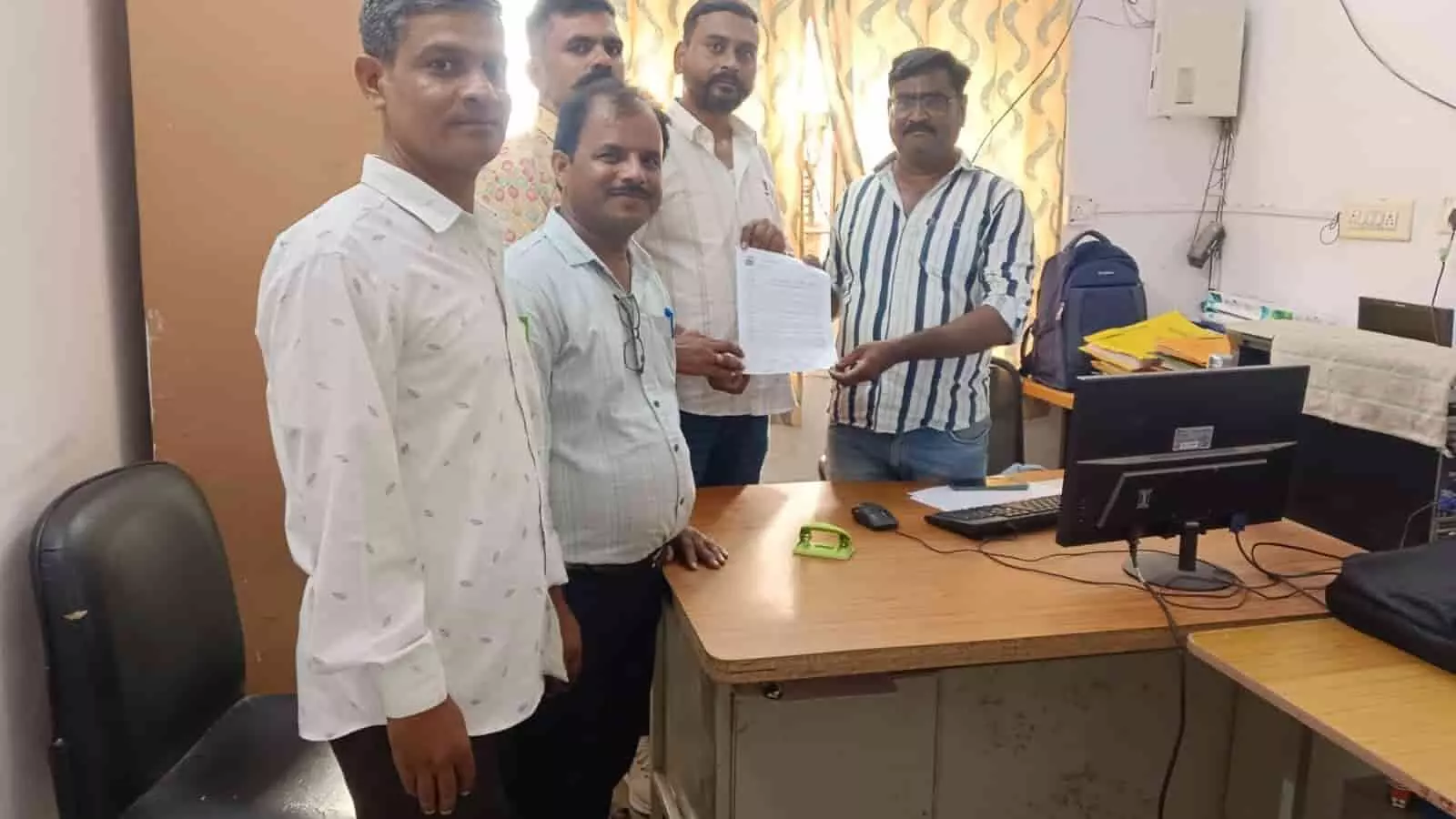 तस्वीर में एक कार्यालय कक्ष में खड़े होकर अधिकारी को ज्ञापन सौंपते संविदा कर्मचारी दिख रहे हैं।