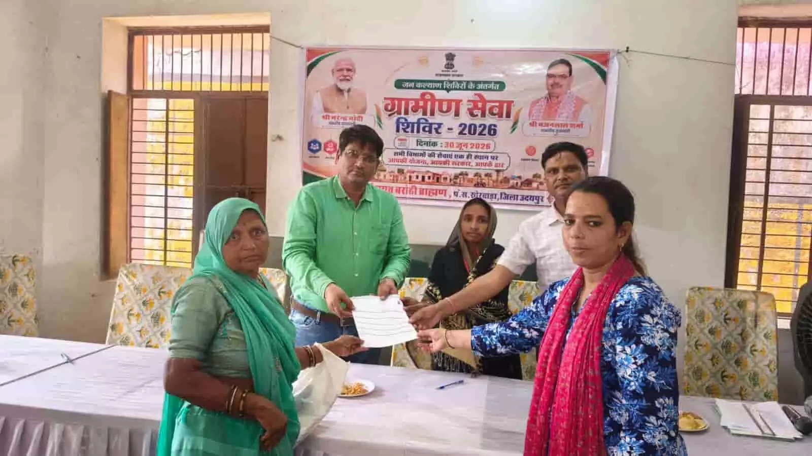 ग्रामीण सेवा शिविर में महिला लाभार्थी को प्रमाण पत्र सौंपते अधिकारी।
