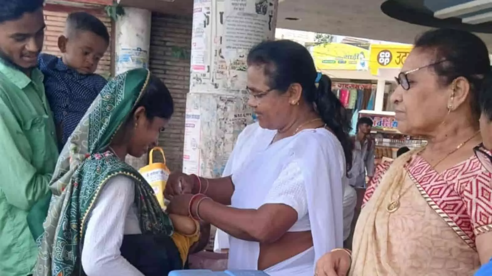 तस्वीर में पोलियो बूथ पर स्वास्थ्यकर्मी द्वारा बच्चे को दवा पिलाते हुए दिखाया गया है।