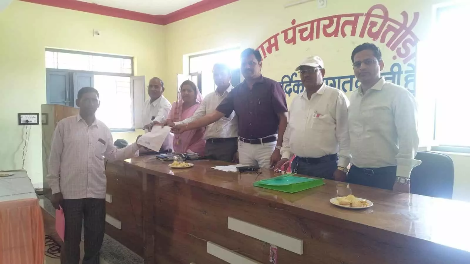 तस्वीर में अधिकारी और जनप्रतिनिधि चित्तौड़ा ग्राम पंचायत भवन में ग्रामीण को प्रमाण पत्र सौंप रहे हैं।